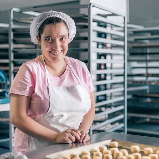 Frau in Arbeitskleidung in einer Bäckerei